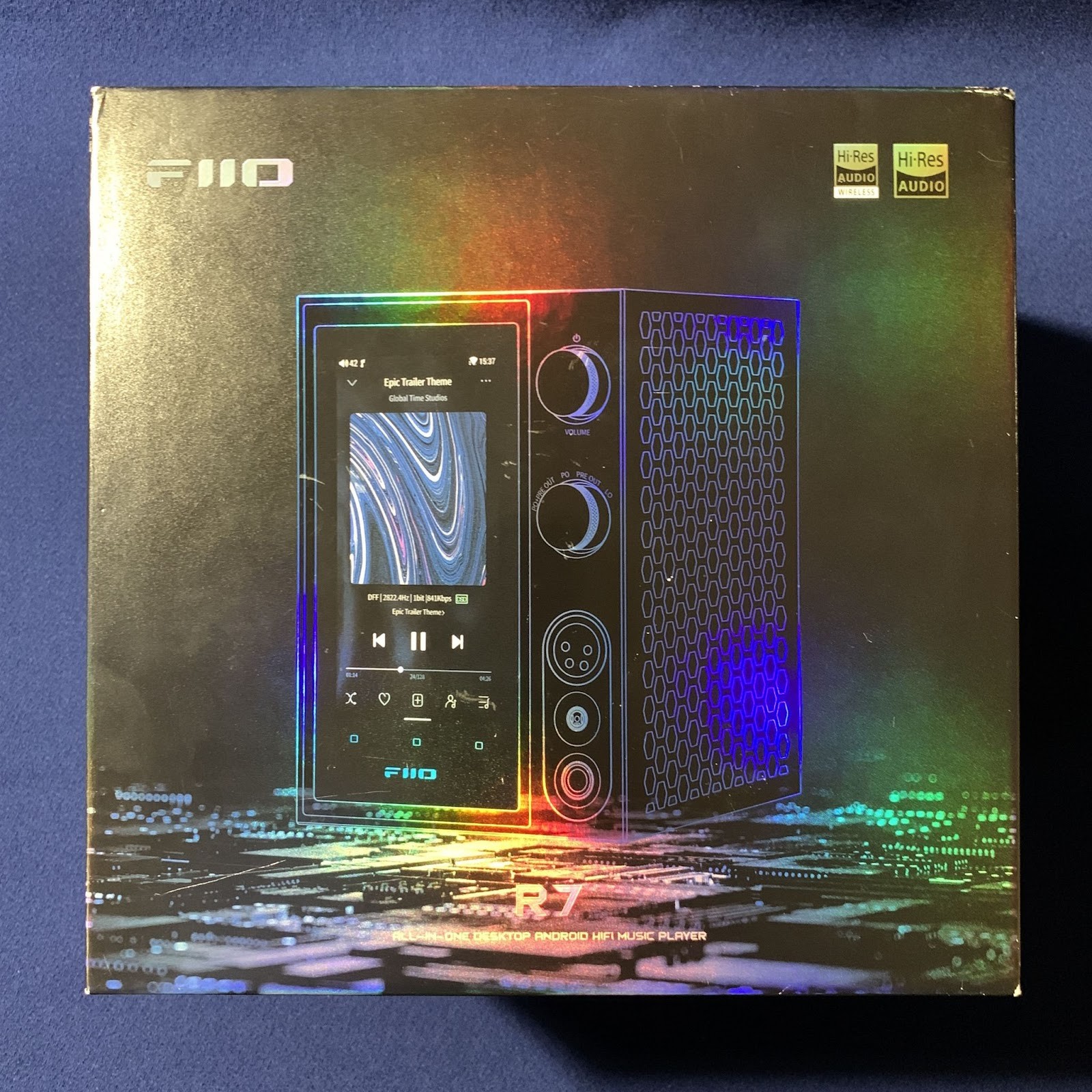 FiiO R7 comes in a sturdy cardboard box, shaped like a cube. Its design has a holographic effect - in bright light the surface shimmers with all the colors of the rainbow.